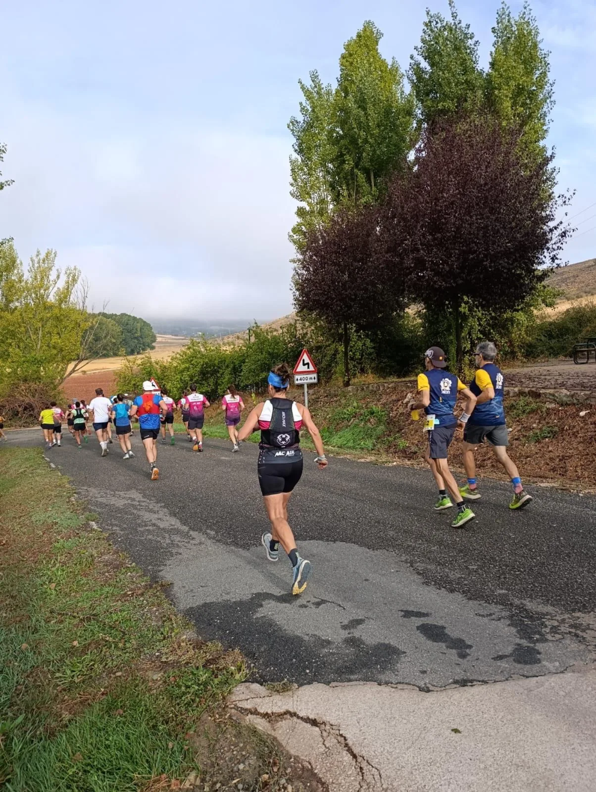 Corredores por la carretera entre chopos